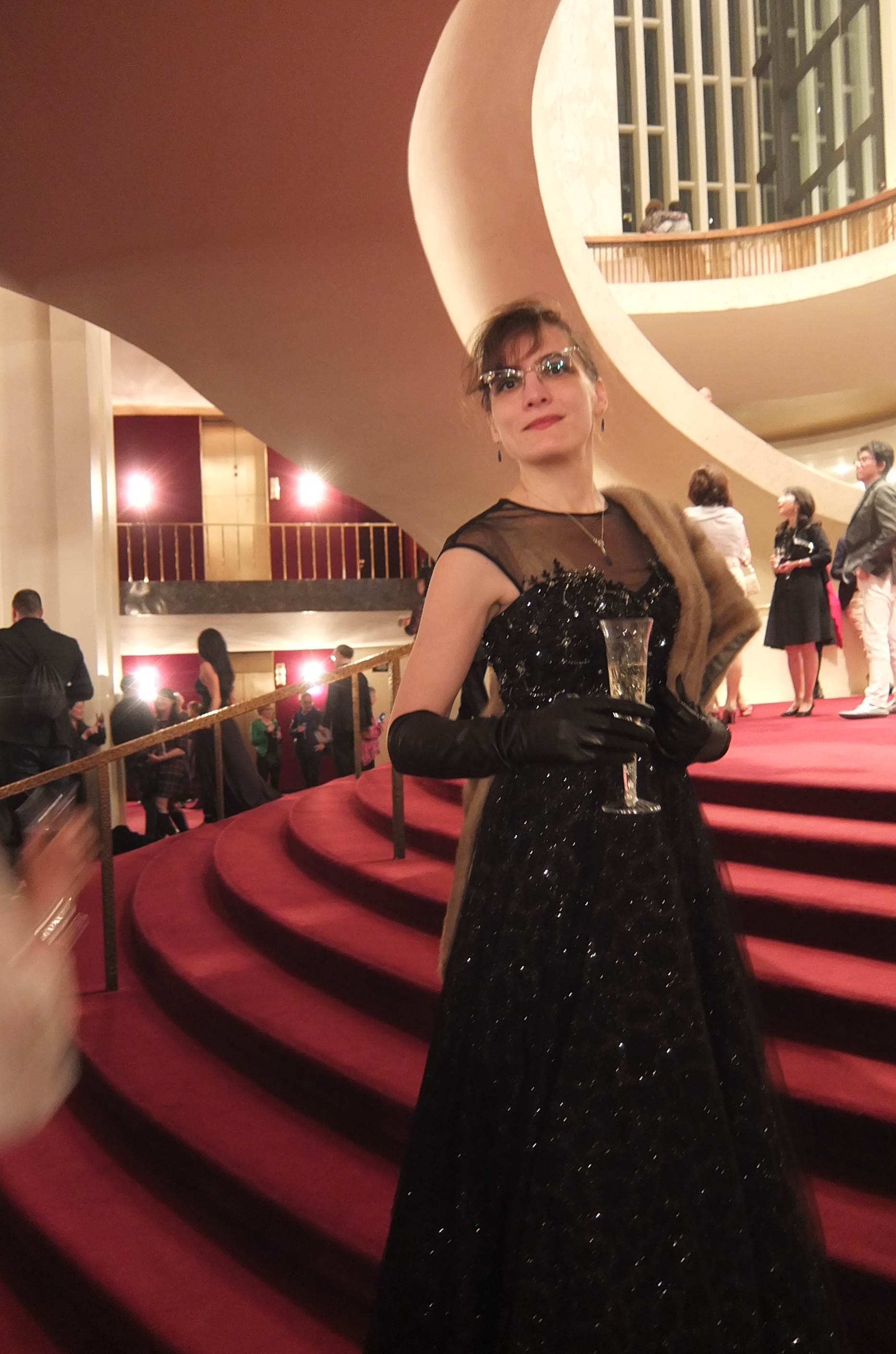 Marie in evening gown with champagne glass at the metropolitan opera