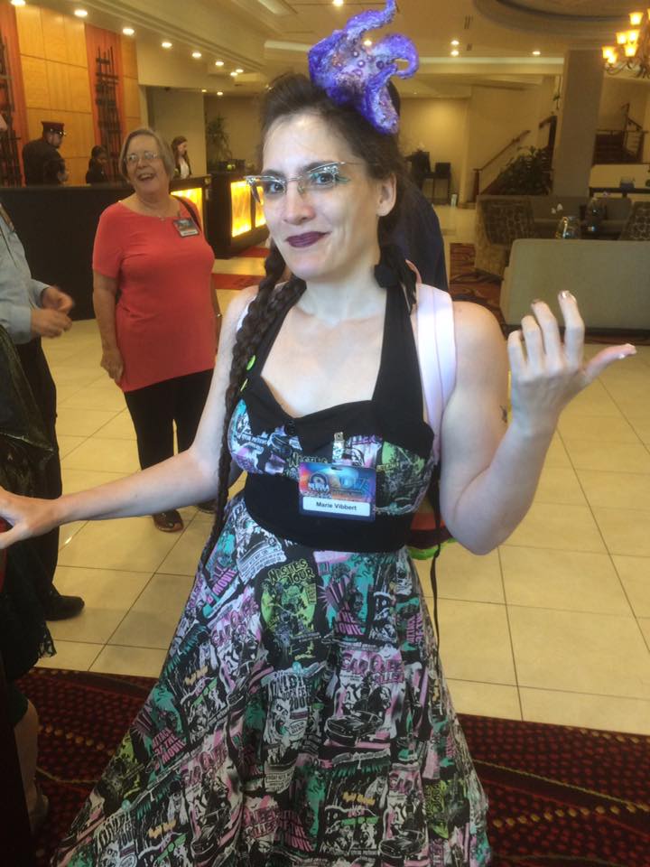 Marie smirks with frosting on her fingers at the Nebulas in 2017