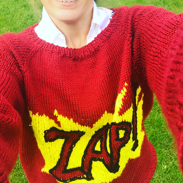 a floppy red sweater that says Zap!