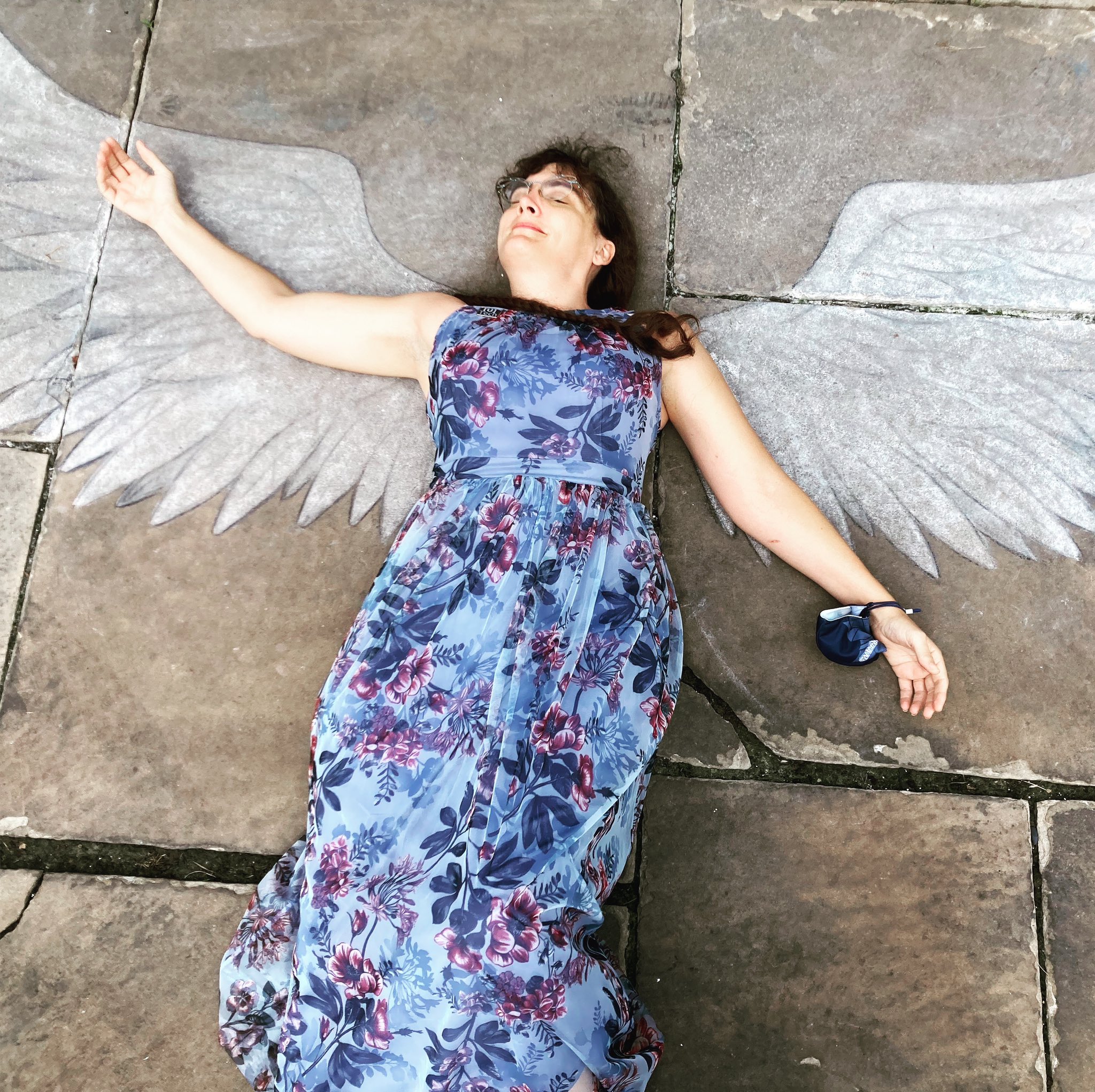 Marie lays on a chalk drawing of angel wings.