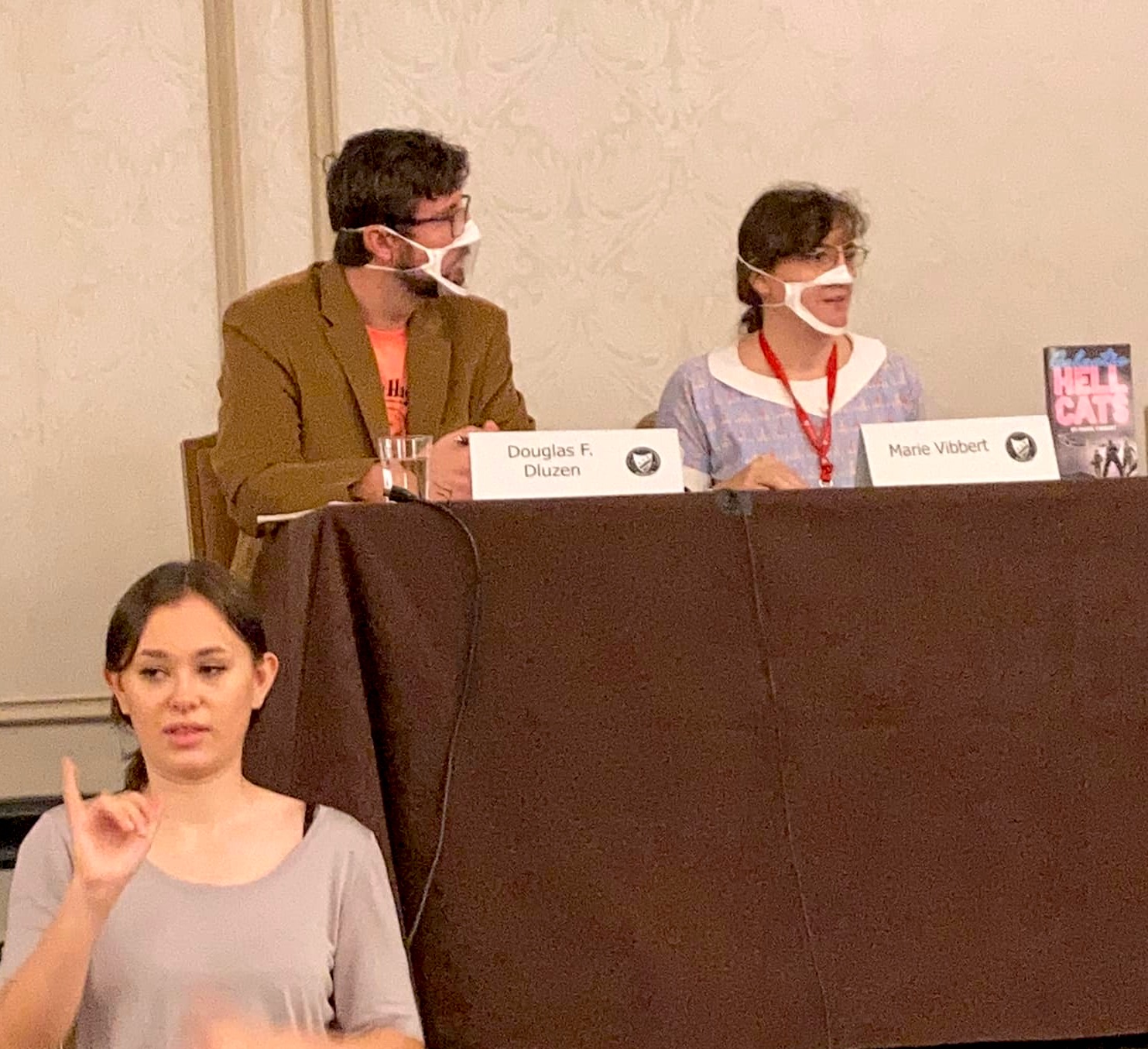 Marie Vibbert and Douglas F. Dluzen at a conference table with ASL interpreter in foreground