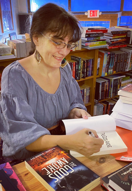 woman signing books in bookstore