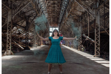 Marie throws up teal chalk dust like she's casting magic in an abandoned factory.