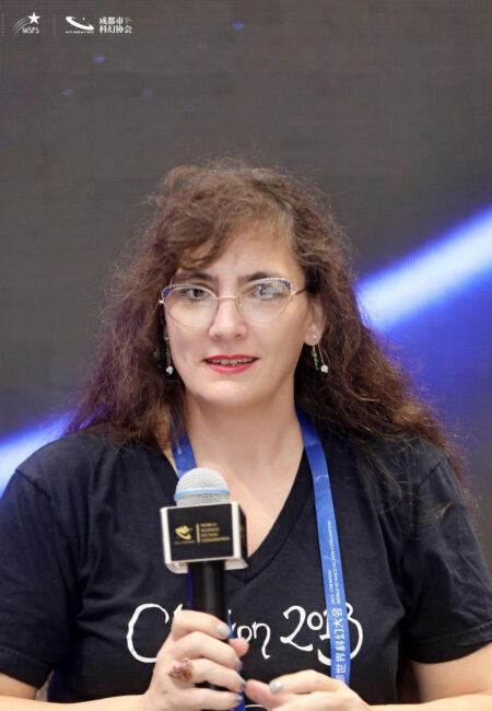 Woman with microphone in front of plain background