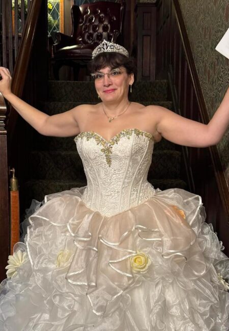 woman in poofy ball gown with tiara descending stairs