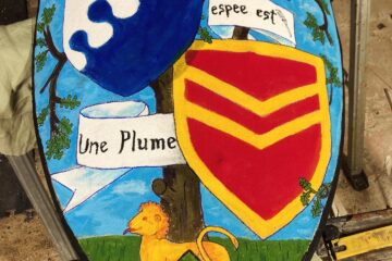 a heater shield decorated with coats of arms, a lion, and a banderole with the words "Mon autre espee es une plume"