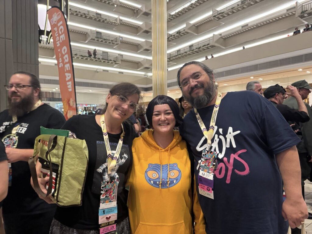 Group photo in a hotel lobby surrounded by lots of other people 